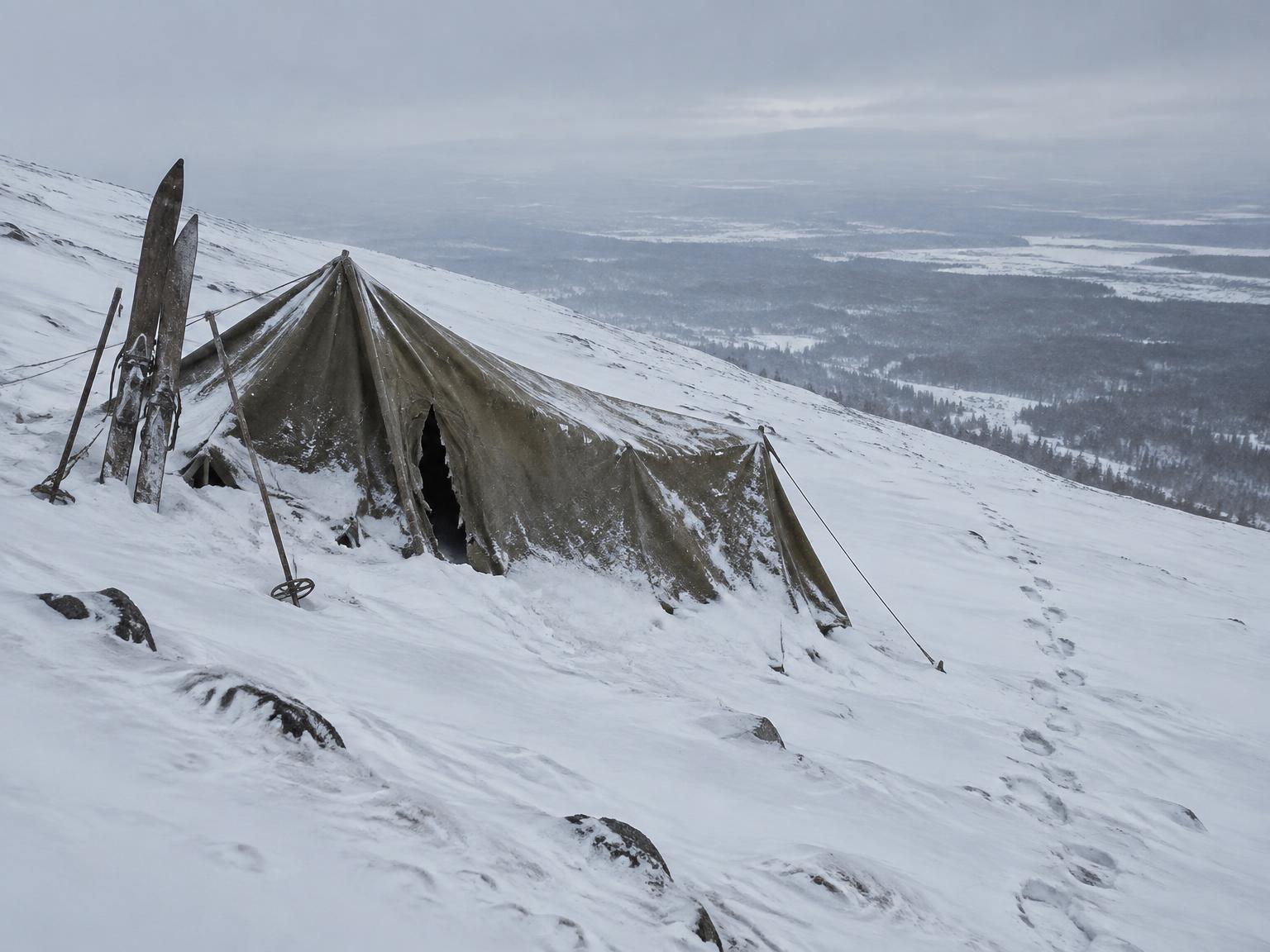 Documentary-style reconstruction of the partly collapsed expedition tent alone on the snowy slope