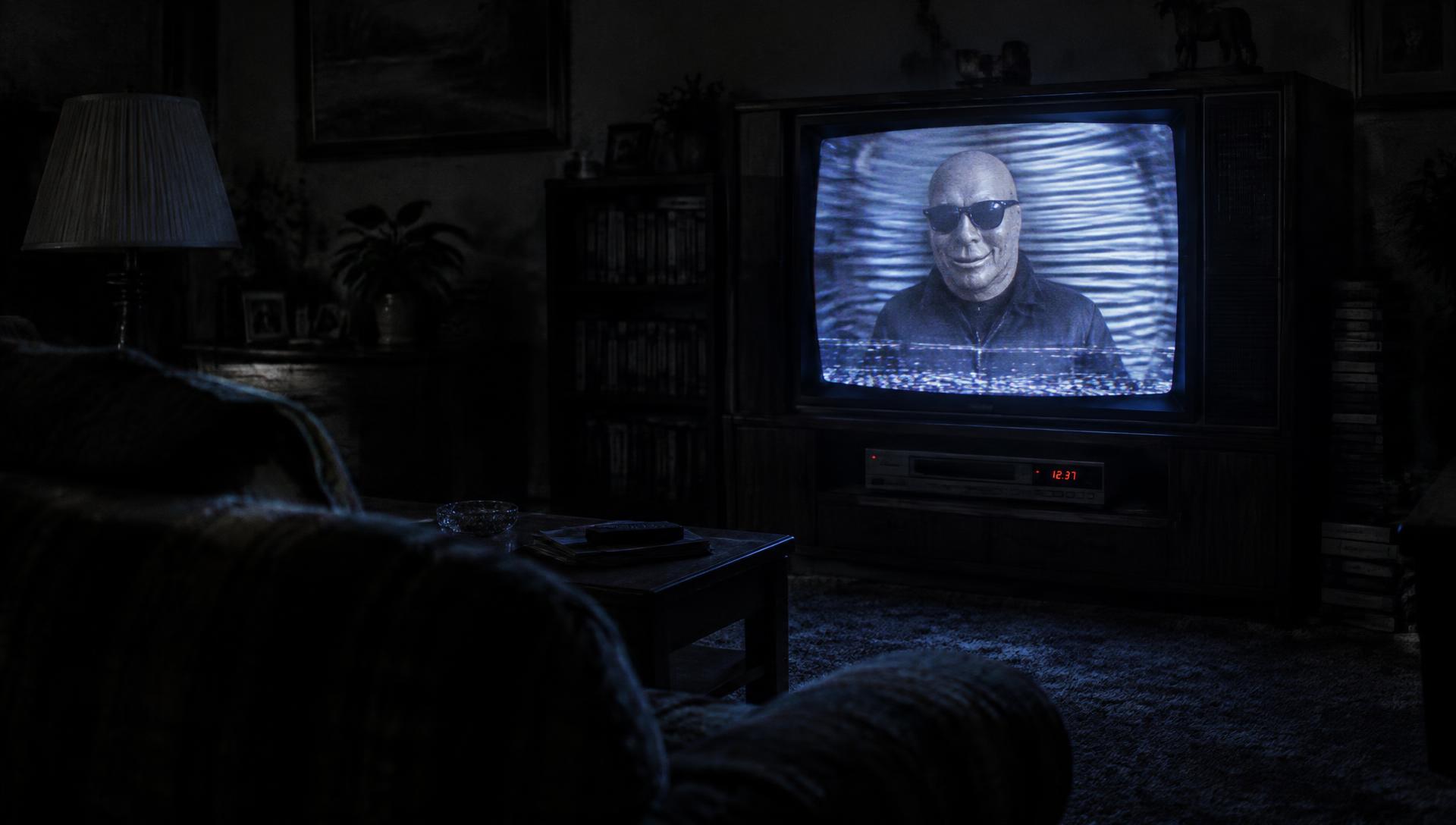 Illustrative reconstruction of a dark 1980s living room lit by a CRT television showing a distorted broadcast of a masked figure